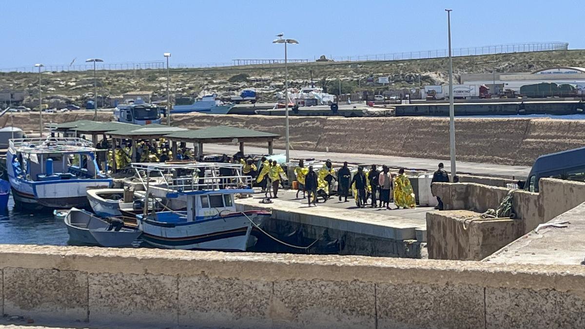 Varios migrantes llegados desde el norte de África desembarcan en la isla italiana de Lampedusa para dirigirse al centro de acogida.