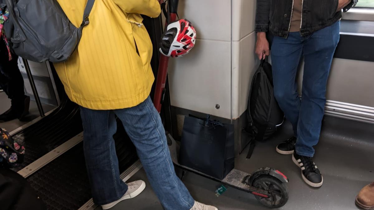Imagen de un joven que viaja en el metro de Bilbao con un patinete.