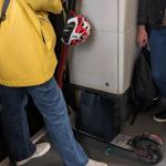 Imagen de un joven que viaja en el metro de Bilbao con un patinete.