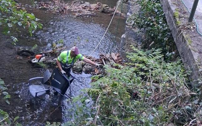 Operario retirando sillas de plástico del cauce de uno de los ríos de Lemoa