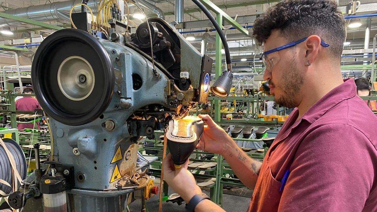 Un joven trabajador dentro de una fábrica de calzado.