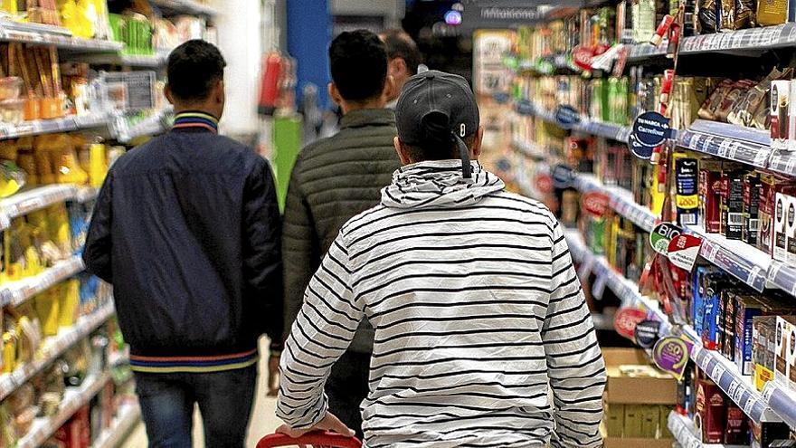 Menores migrantes hacen la compra en un supermercado en Pamplona.