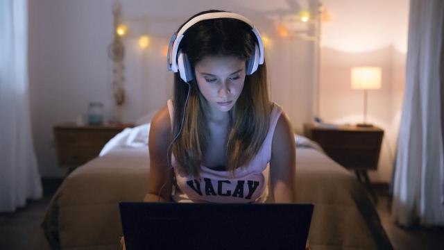 Joven utilizando el ordenador en su habitación.