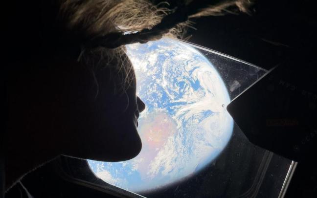 La astronauta Christina Koch, miembro de la misión Artemis II, contempla la Tierra desde la nave Orión.