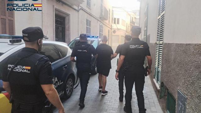 El detenido, de espaldas, escoltado por varios agentes de la Policía Nacional.