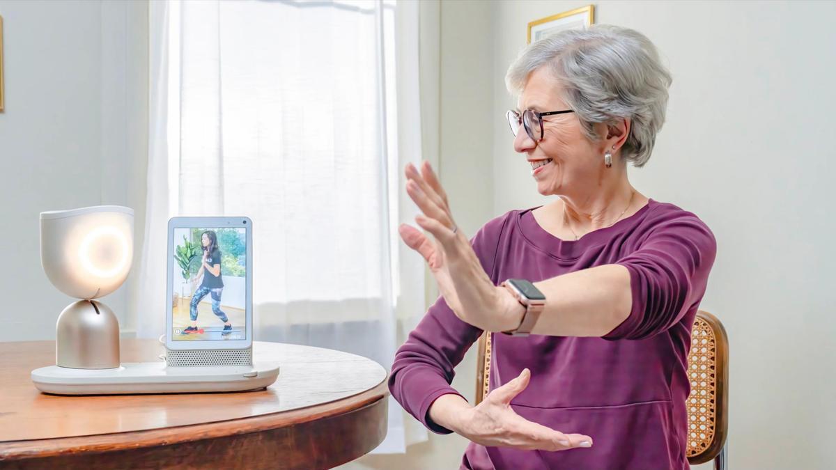 Una mujer mayor interactúa con el robot ElliQ.