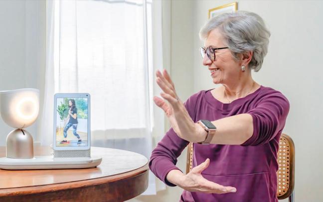 Una mujer mayor interactúa con el robot ElliQ.