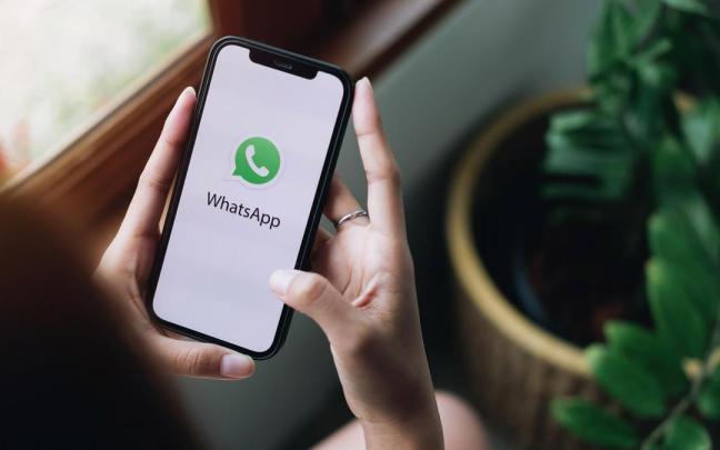 Una mujer abre la aplicación de WhatsApp en su teléfono móvil.