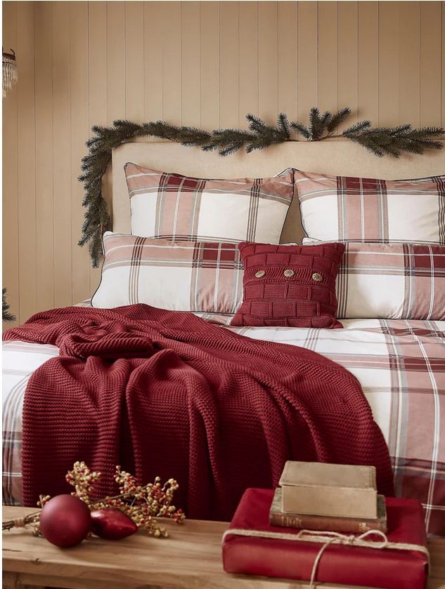 Textiles en rojo y pequeños adornos da un aire navideño a este dormitorio. Textiles en rojo y pequeños adornos da un aire navideño a este dormitorio.