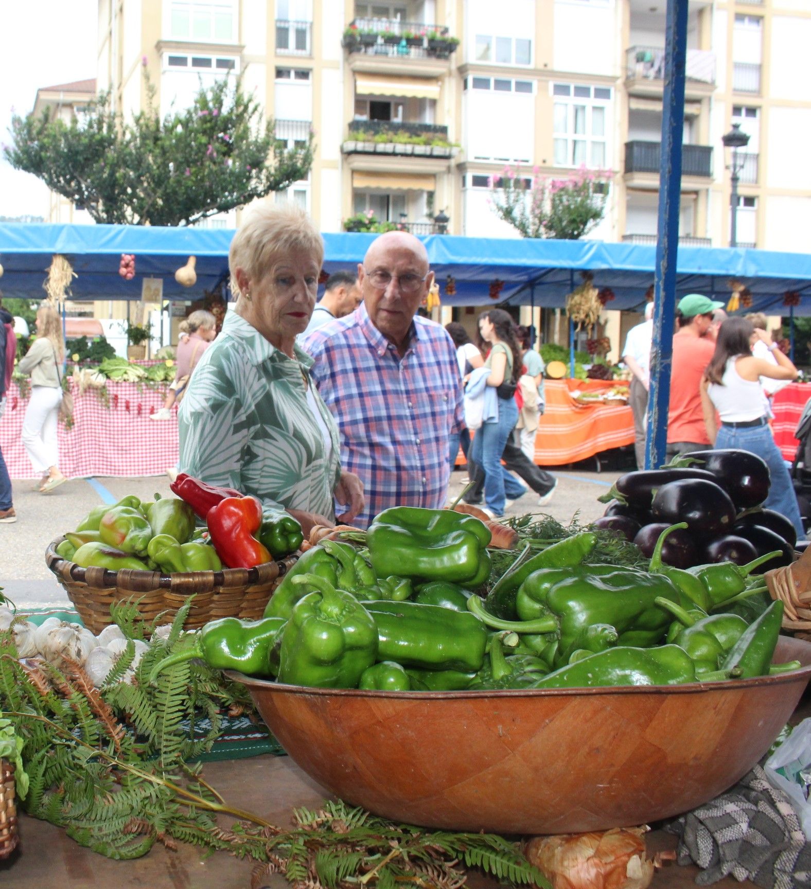 El público recorre con todo detalle los puestos perfectamente engalanados para la ocasión.