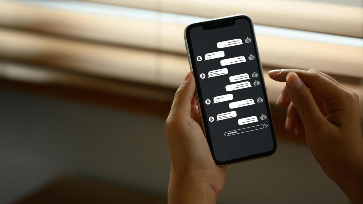 Una mujer interactúa con un chatbot conversacional en el móvil.