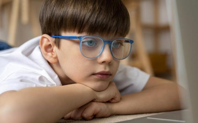 Un niño mira un ordenador a través de sus gafas