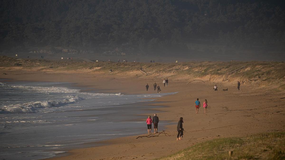 Varias personas disfrutan de la playa.