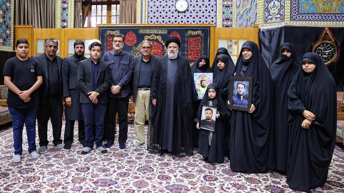 El presidente de Irán, Ebrahim Raisí, junto a familiares de miembros de las fuerzas de seguridad que murieron en las protestas.