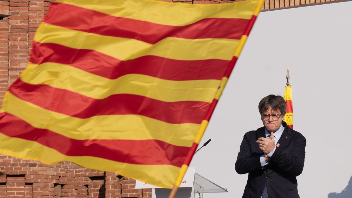 El expresidente de la Generalitat de Catalunya Carles Puigdemont aplaude durante un acto de bienvenida organizado por entidades independentistas en el paseo Lluís Companys