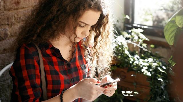 Una mujer hace un bizum con el teléfono móvil.