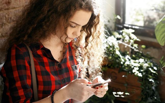 Una mujer hace un bizum con el teléfono móvil.