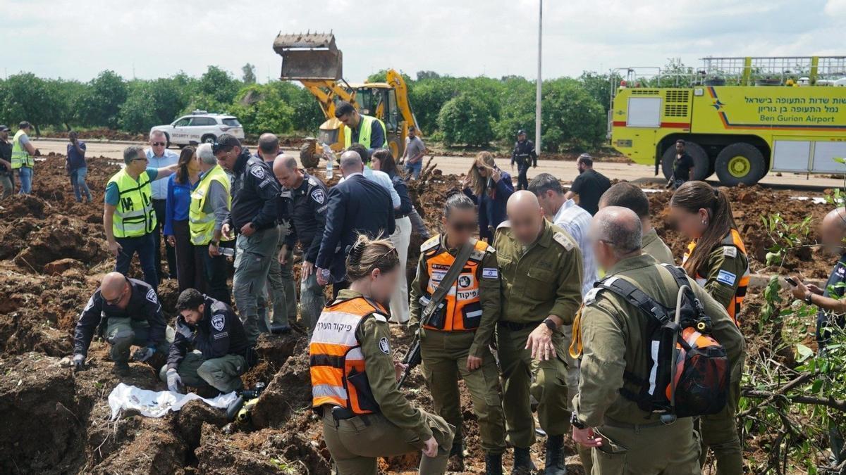Militares israelíes observan los restos del misil caído junto al aeropuerto de Tel Aviv.