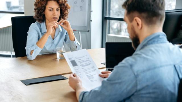 Un responsable de RRHH lee el curriculum de una candidata.