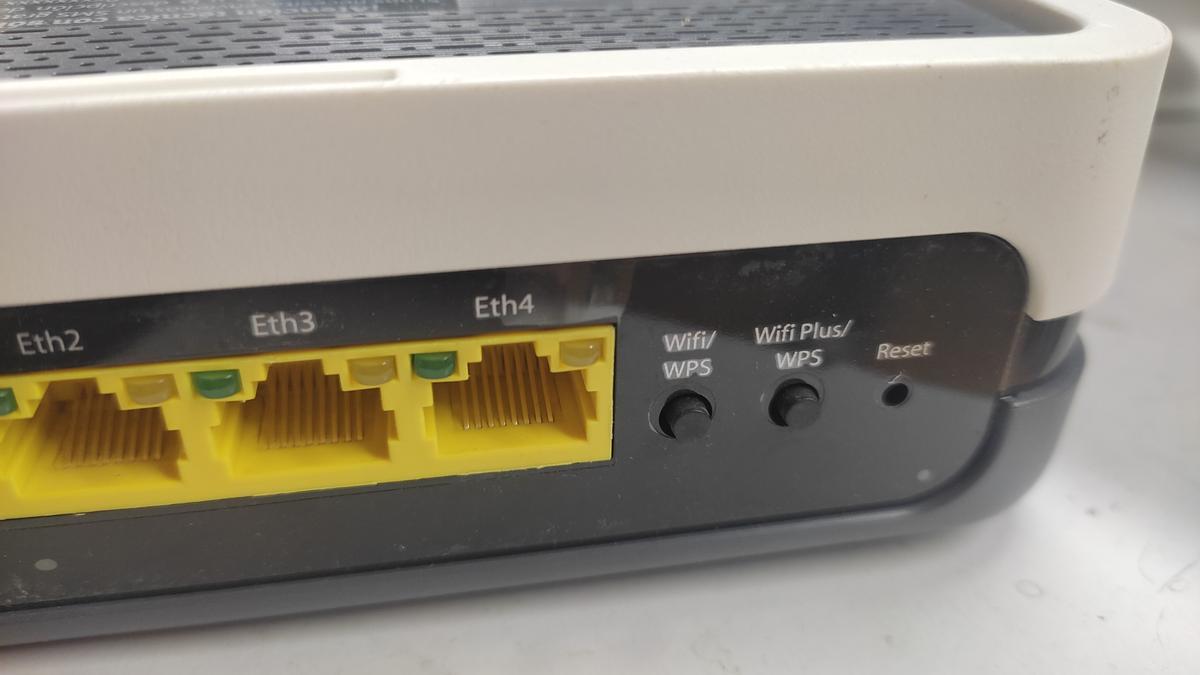 Dos botones WPS en la trasera de un router.