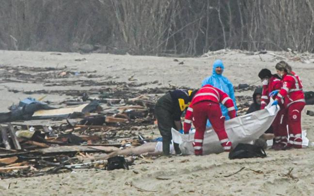 Los servicios de emergencias cubren uno de los cuerpos que aparecieron en una playa de Calabria. Los servicios de emergencias cubren uno de los cuerpos que aparecieron en una playa de Calabria.