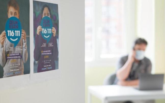 Un profesional de Zeuk Esan atiende una llamada telefónica hecha por un menor al servicio de ayuda a la infancia y adolescencia