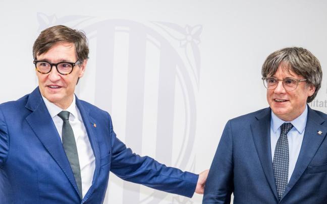 El presidente de la Generalitat, Salvador Illa, saluda al presidente de Junts per Catalunya, Carles Puigdemont, durante una reunión en agosto de 2025, en Bruselas