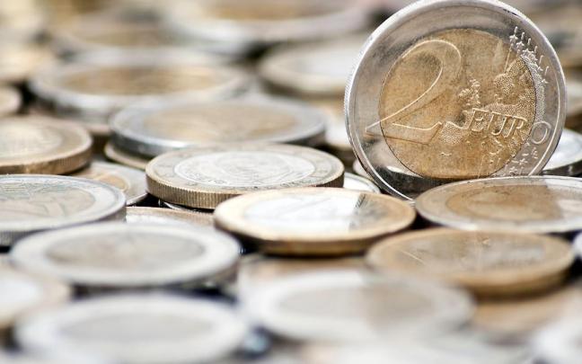 Una moneda de 2 euros junto a otras similares. Una moneda de 2 euros junto a otras similares.