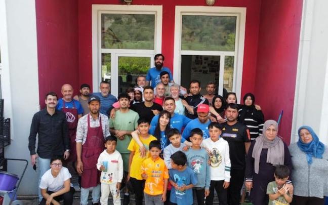 Rikardo Babarro, goialdean erdian kamiseta gorriarekin, Lesbosen, boluntarioekin eta kanpamentuko jendearekin.