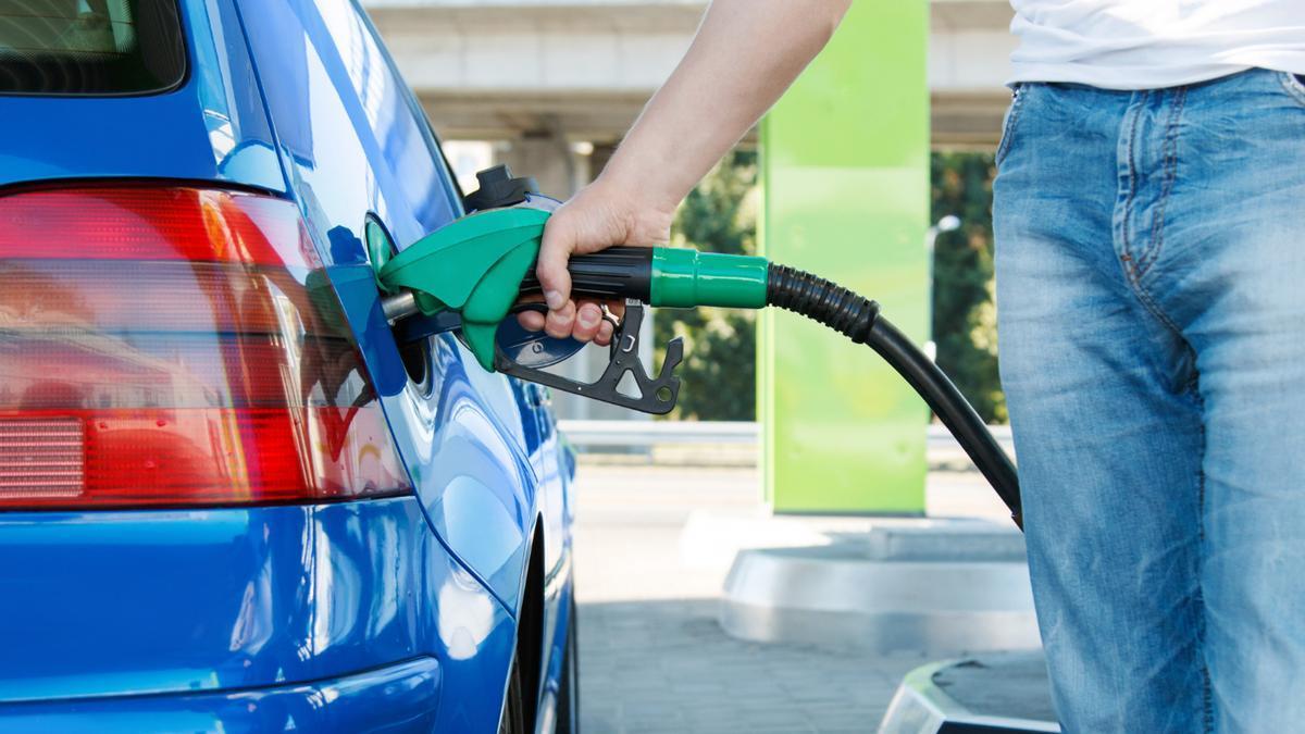 Un hombre, repostando en una gasolinera.