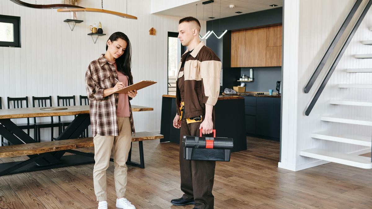 La propietaria de una vivienda firma un documento tras una reparación.