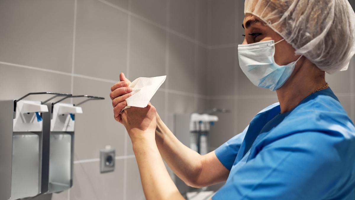Una trabajadora sanitaria se lava las manos.