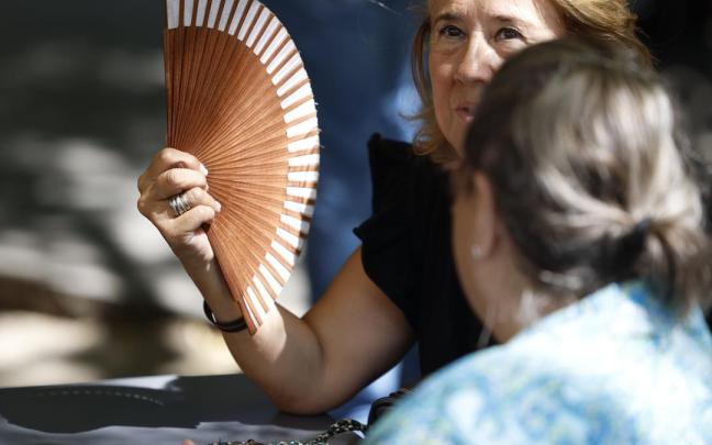 Una mujer se abanica para mitigar los efectos del calor.