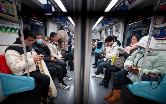 Varias personas en el interior de un metro de Shanghái.