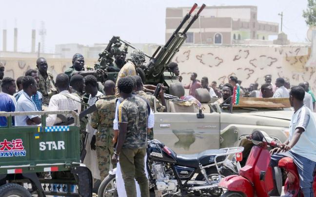 Varios ciudadanos saludan a militatares del Ejército sudanés en la localidad de Puerto Sudán.