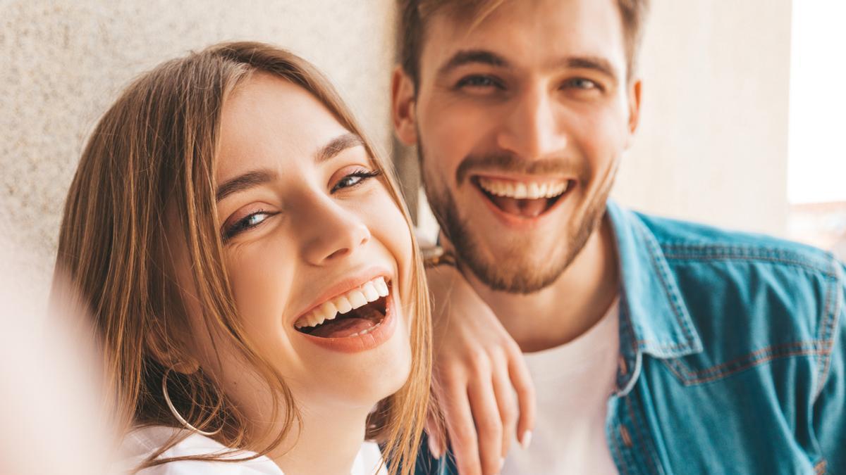 Pareja sonríe en una fotografía.