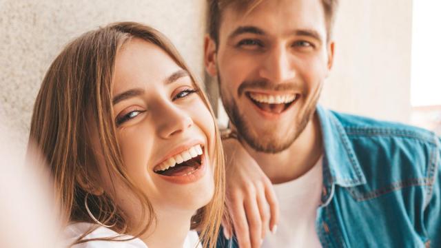 Pareja sonríe en una fotografía.