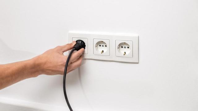 Una persona desconecta un enchufe de la pared