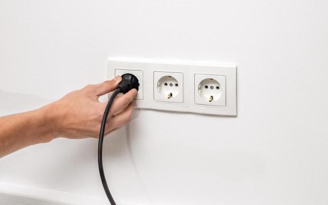 Una persona desconecta un enchufe de la pared