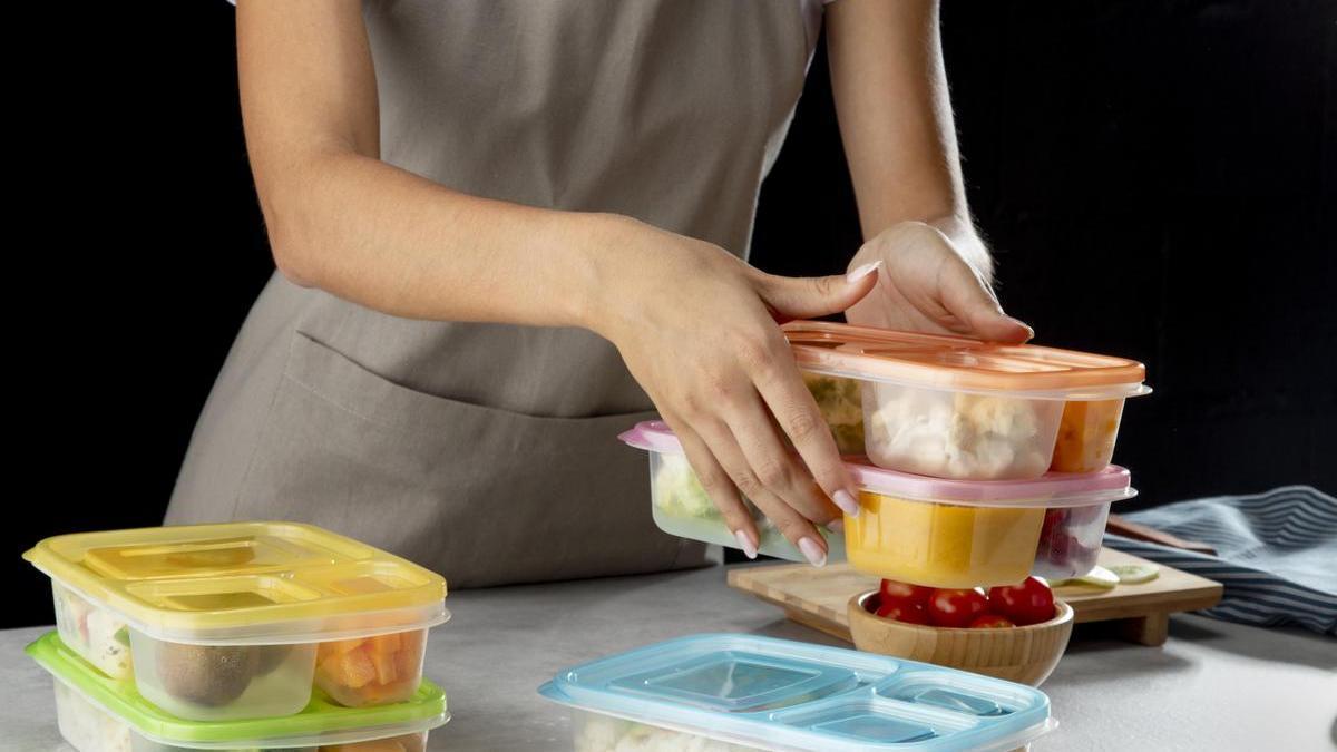 Una mujer prepara varios envases de alimentos.