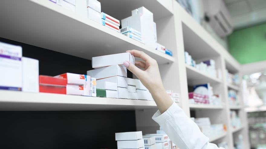 Una farmacéutica alcanza un medicamento.