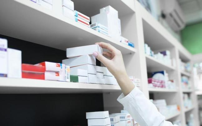 Una farmacéutica alcanza un medicamento.