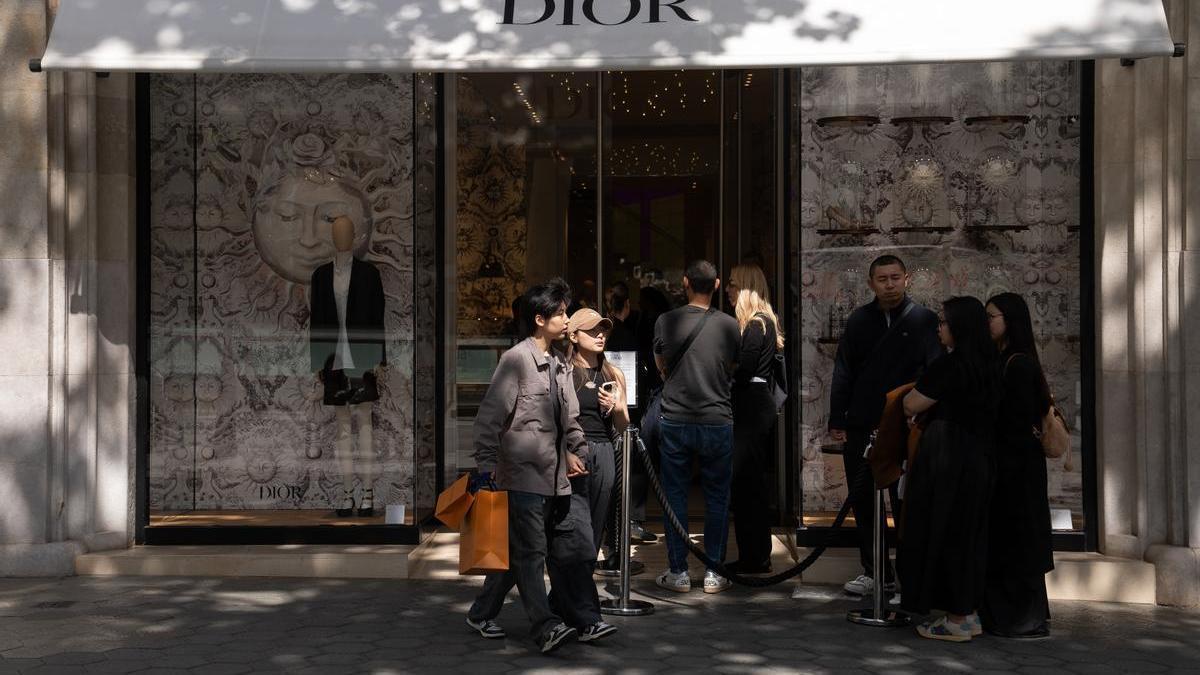 Varias personas delante de la tienda de Dior, en el Paseo de Gracia, Barcelona.