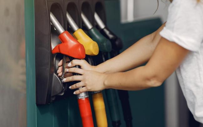 Una persona repostando en una gasolinera