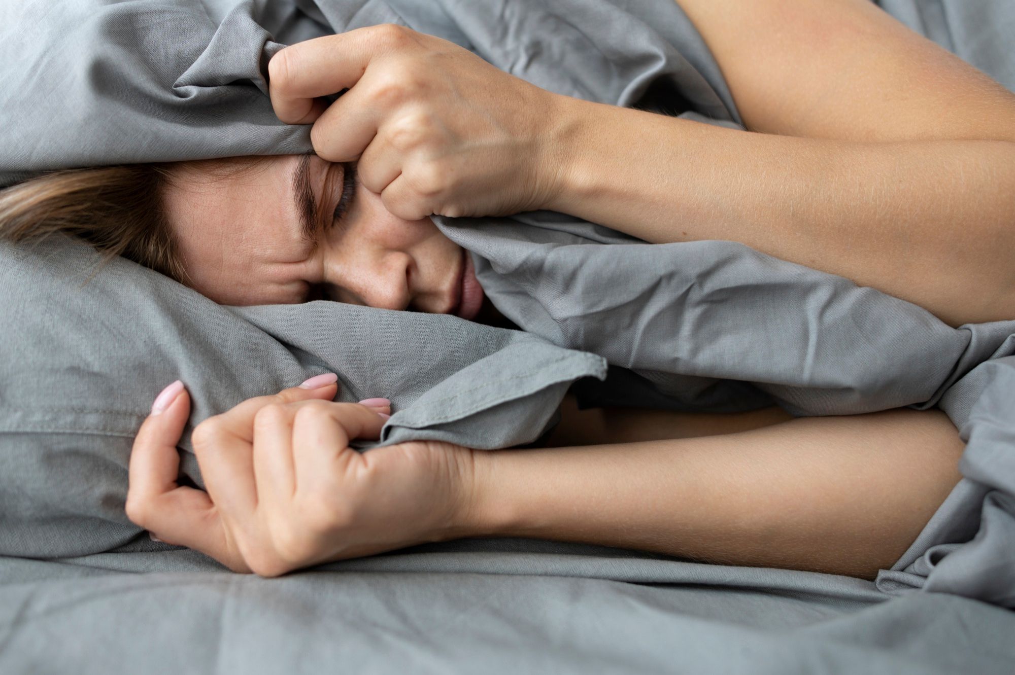 Una mujer muestra gesto de enfado por no poder dormir.