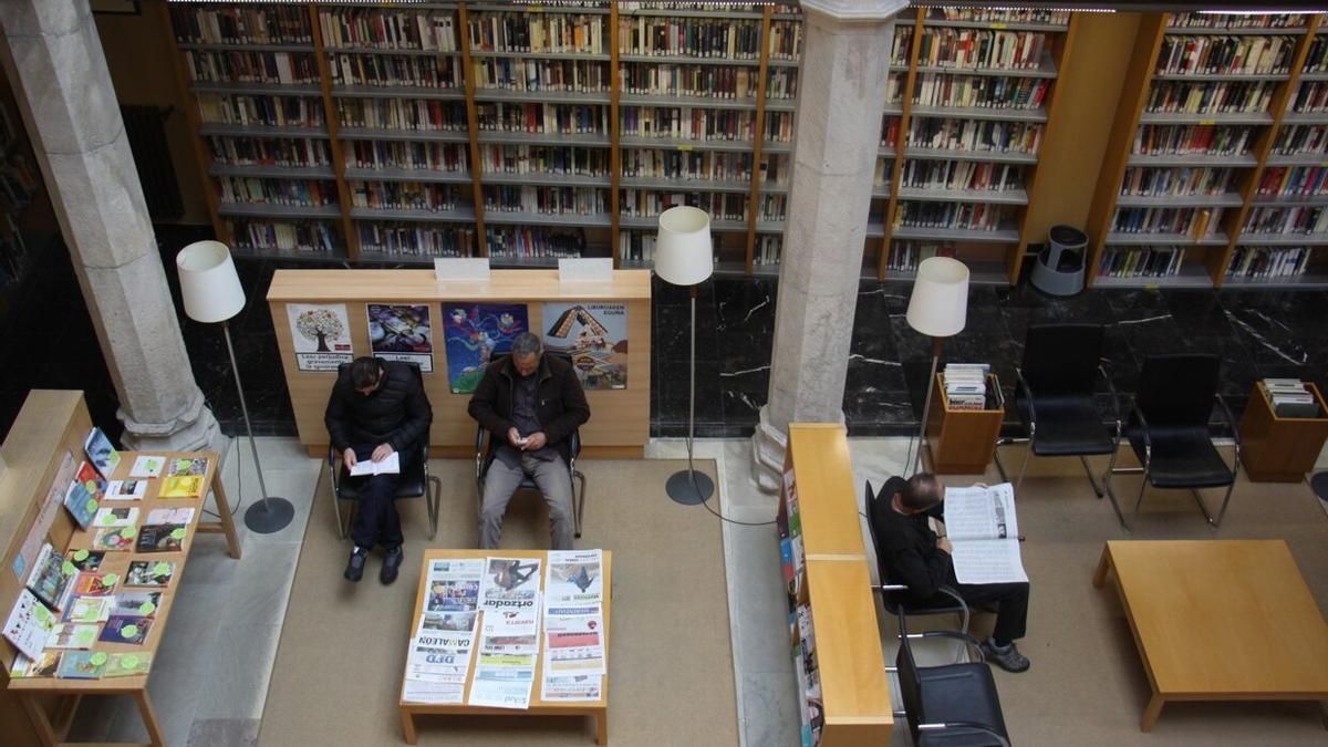 Varias personas leyendo en la Biblioteca de Estella.