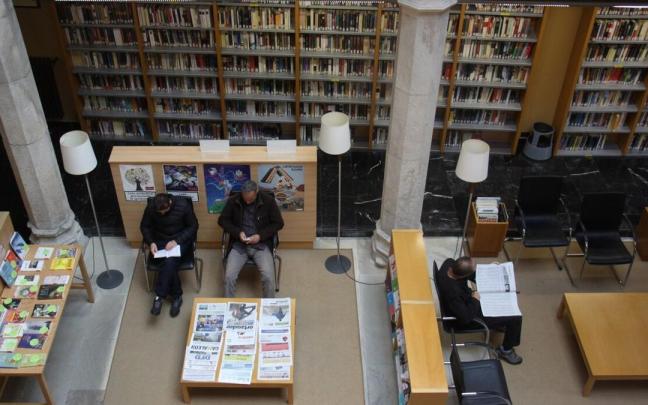 Varias personas leyendo en la Biblioteca de Estella.