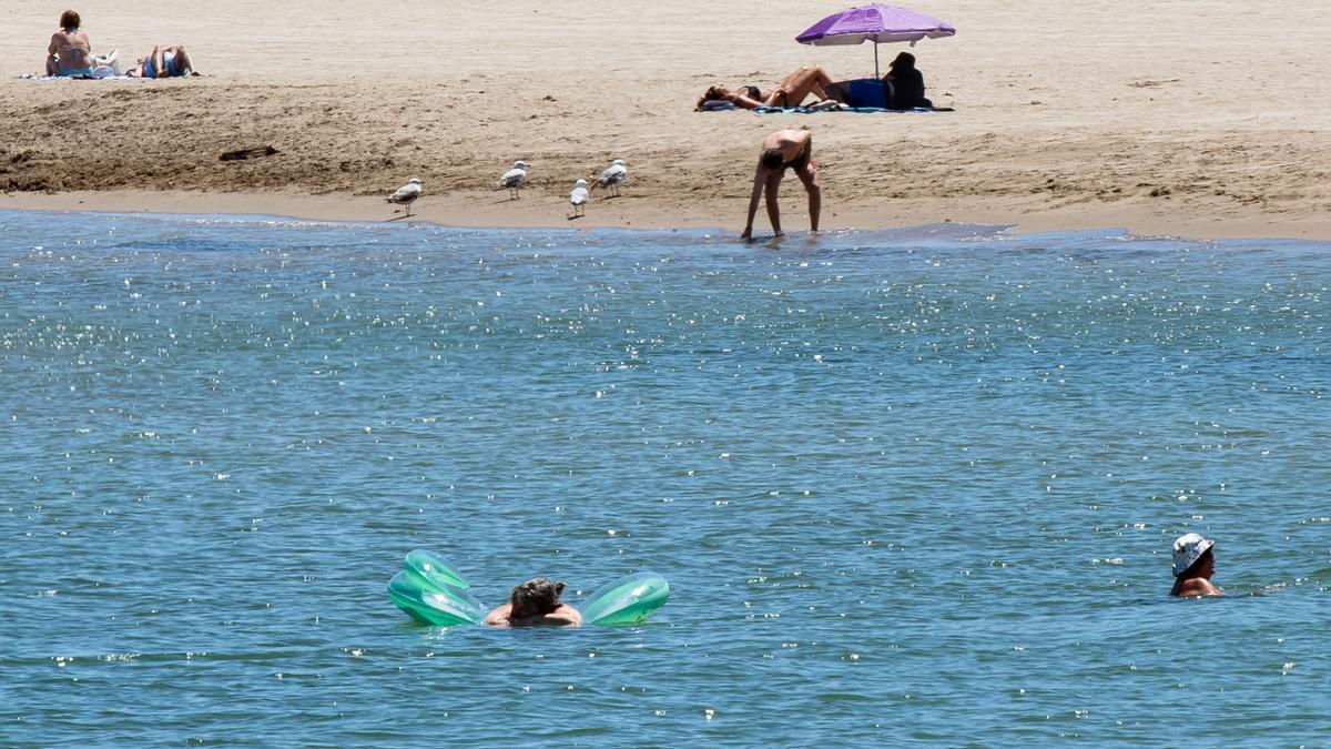 Varias personas en una playa.