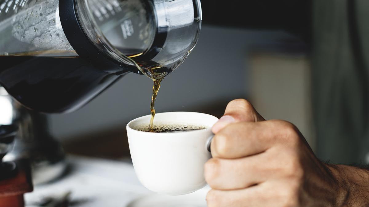 Un hombre se sirve una taza de café.