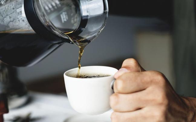 Un hombre se sirve una taza de café.